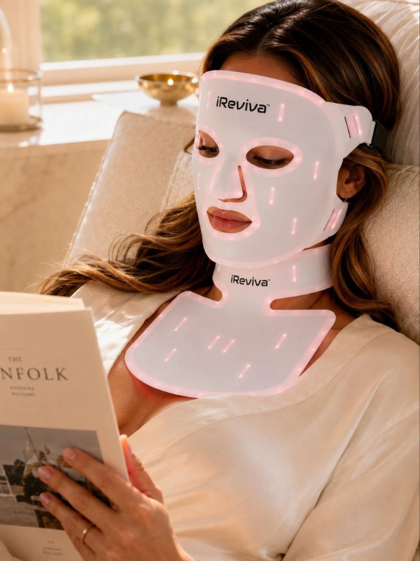 Woman wearing iReviva Pro 234 LED light therapy system for face, neck and chest